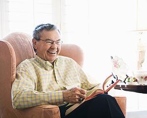 Man sitting in chair reading a book
