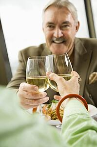Mature couple dining and toasting in fancy restaurant.