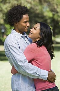 Couple smiling and embracing in park
