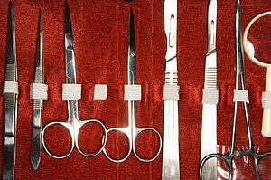 Medical kit with tweezers, scissors, scapel.
