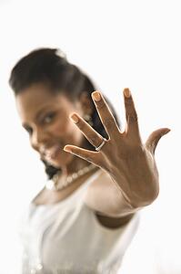 Portrait of a mid-adult bride showing ring to viewer