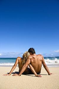 Couple sitting close together on beach