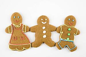 Three male and female gingerbread cookies holding hands.