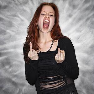 Portrait of pretty young redhead woman giving middle finger gesture.
