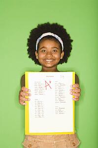 Girl holding out graded school assignment