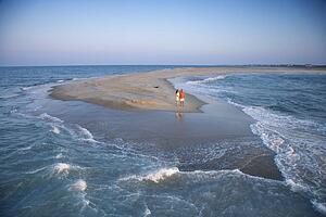 Birds eye view of couple on sandbar at Bald Head Island, North Carolina during sunrise