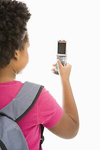 Girl with backpack looking at cell 