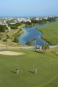 Aerial view of two people palying golf near residential community at Bald Head Island, North Carolina.