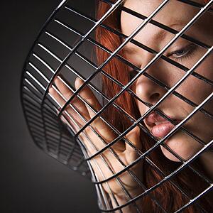 Woman portrait through metal chair 