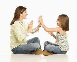 Mother and daughter playing pattycake