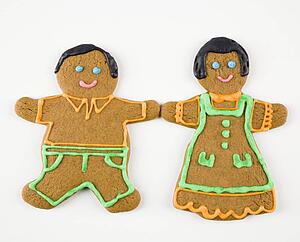 Male and female gingerbread cookies holding hands.