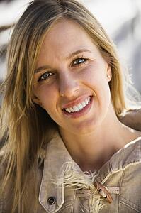 Attractive young adult woman with long hair smiling at viewer.