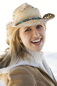 Young woman looking at viewer wearing cowboy hat