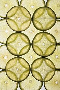 Lime slices arranged in design on white background.