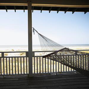 View of beach from porch with railing and hammock at Bald Head Island, North Carolina