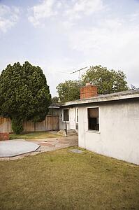 Rear view of home with back yard and patio