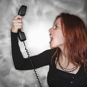 Woman holding telephone and yelling