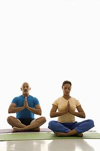 Man and woman sitting in Namaste position