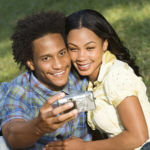 Couple taking pictures in park 