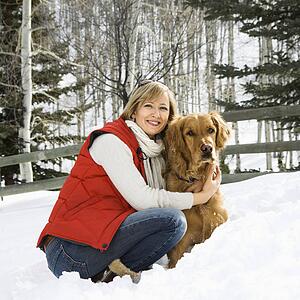 Woman hugging her dog outside in the snow