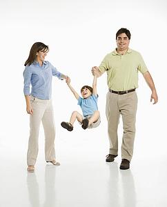 Mother and father swinging son 