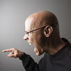 Profile portrait of mid-adult male screaming and pointing