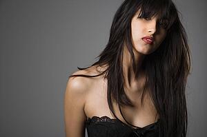 Head and shoulder portrait of pretty young woman with long black hair