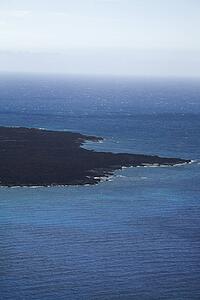 Aerial of lava rock coastline jutting into Pacific ocean on Maui, Hawaii.