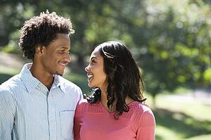 Couple in park looking at each other smiling