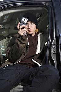 Teen taking a picture from his car.