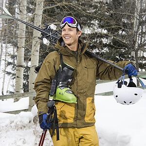 Man in walking carrying ski equipment