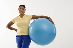 Woman standing and holding exercise ball