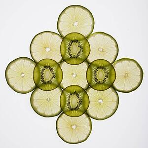 Lime and kiwi fruit slices arranged on white background.
