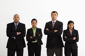 Portrait of businessmen and businesswomen standing with arms crossed looking serious.