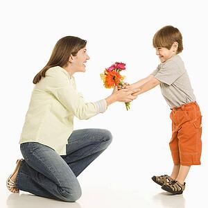Son giving bouquet of flowers to mother.