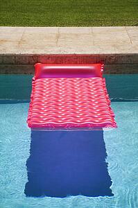 Pink float in empty swimming pool.