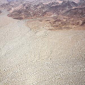 Aerial view of torrid California desert with rocky landforms.