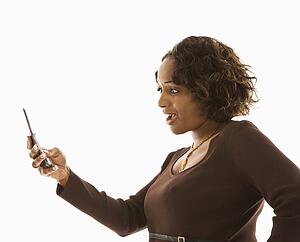 Woman looking at cellphone with shocked expression