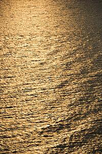 Sun reflecting golden on Atlantic ocean.