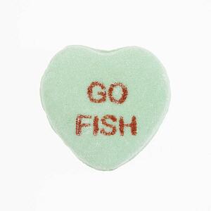 Green candy heart that reads go fish against white background.