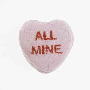 Purple candy heart that reads all mine against white background.