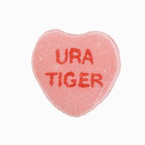 Pink candy heart that reads URA tiger against white background.