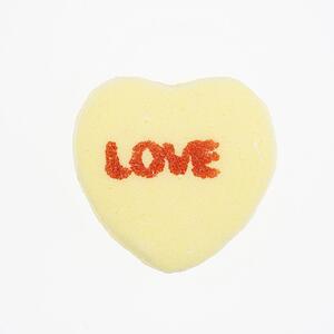 Yellow candy heart that reads love against white background.