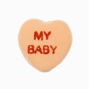 Orange candy heart that reads my baby against white background.