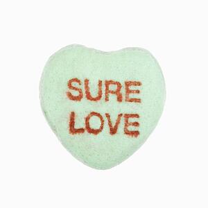 Green candy heart that reads sure love against white background.