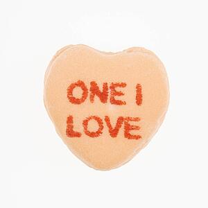 Orange candy heart that reads one I love against white background.