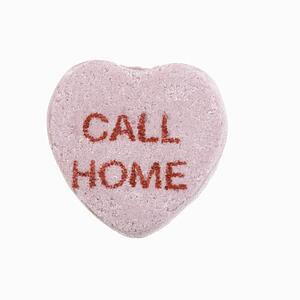 Purple candy heart that reads call home against white background.