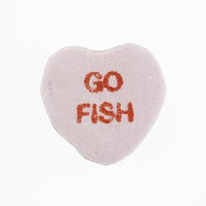 Purple candy heart that reads go fish against white background.