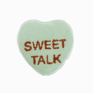 Green candy heart that reads sweet talk against white background.