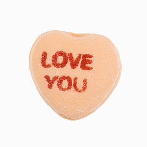 Orange candy heart that reads love you against white background.